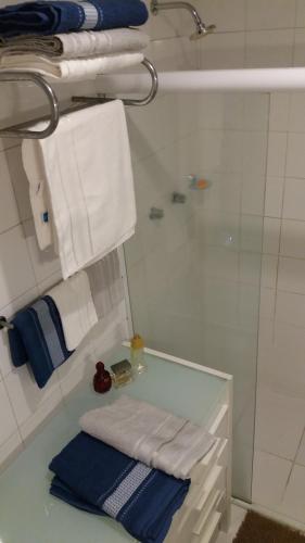 y baño con ducha, toallas y lavamanos. en Apto. Confortável em Copacabana, en Río de Janeiro