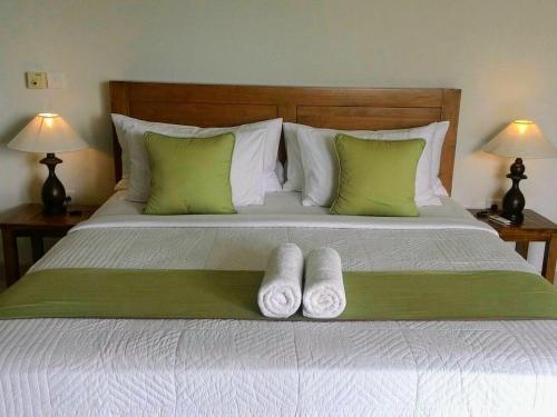a bedroom with a bed with two towels on it at ThreeWin Homestay in Ubud