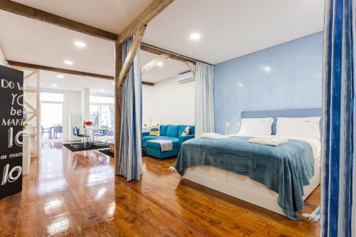 ein Schlafzimmer mit einem Bett und einer blauen Wand in der Unterkunft FLH Graça Artistic Studio in Lissabon