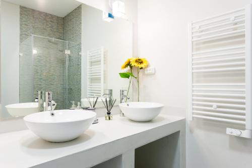 ein weißes Badezimmer mit 2 Waschbecken und einem Spiegel in der Unterkunft FLH Graça Artistic Studio in Lissabon