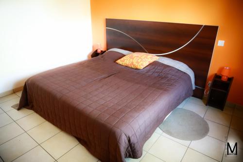 GaillèresにあるAu Coeur Des Landesのベッドルーム1室(大型ベッド1台、木製ヘッドボード付)