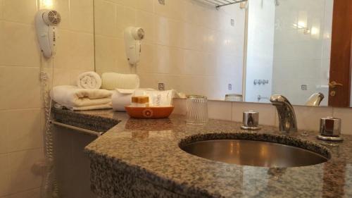 W łazience znajduje się umywalka i lustro. w obiekcie Ohasis Hotel Jujuy & Spa w mieście San Salvador de Jujuy