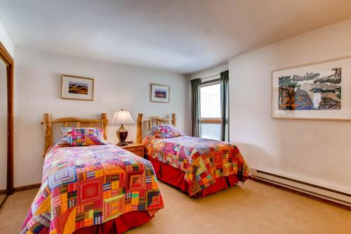 a bedroom with two beds and a window at The Plaza Condominiums by Crested Butte Mountain Resort in Mount Crested Butte