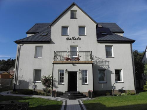 a large white building with a black roof at Willa Ballada in Kuźnica