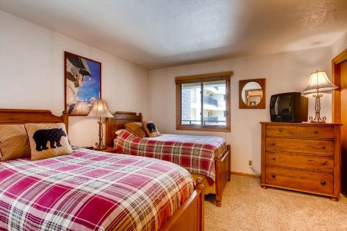 a bedroom with two beds and a tv in it at The Plaza Condominiums by Crested Butte Mountain Resort in Mount Crested Butte