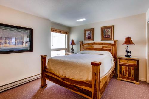 a bedroom with a wooden bed and a window at The Plaza Condominiums by Crested Butte Mountain Resort in Mount Crested Butte
