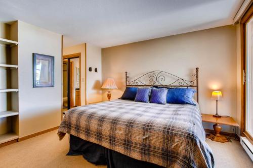 a bedroom with a large bed with blue pillows at The Plaza Condominiums by Crested Butte Mountain Resort in Mount Crested Butte