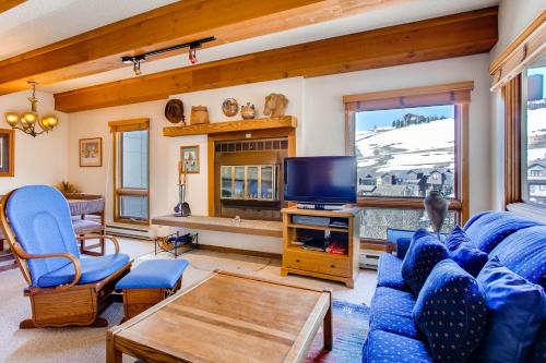 a living room with a blue couch and a tv at The Plaza Condominiums by Crested Butte Mountain Resort in Mount Crested Butte