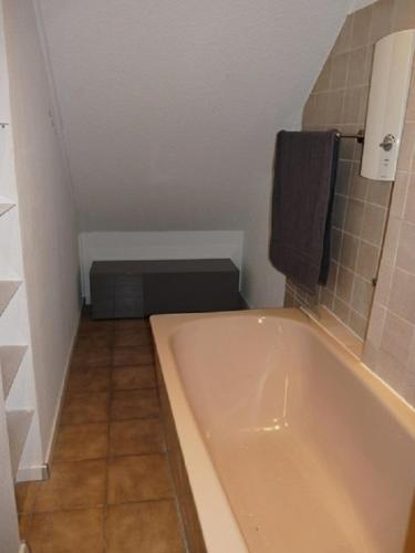 a bathroom with a tub and a tiled floor at Ferienwohnung in Düsseldorf Hassel in Düsseldorf
