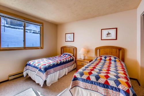 a bedroom with two beds and a window at The Plaza Condominiums by Crested Butte Mountain Resort in Mount Crested Butte