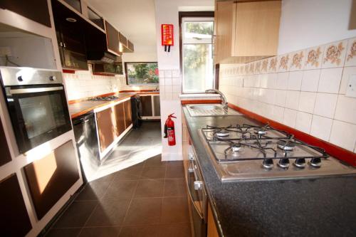a kitchen with a stove and a sink in it at Hill Crescent in London