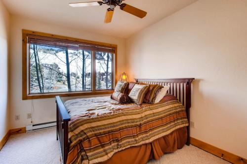 a bedroom with a bed with a ceiling fan and a window at The Plaza Condominiums by Crested Butte Mountain Resort in Mount Crested Butte