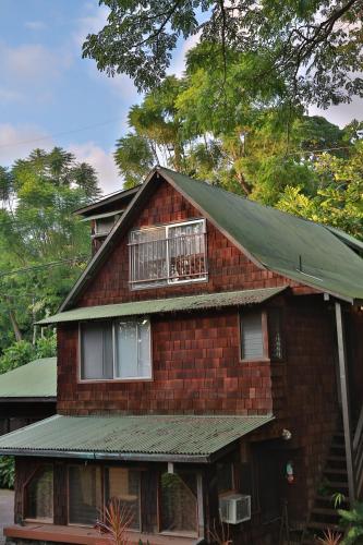 a red brick house with a green roof at Hale Maluhia Country Inn in Kailua-Kona