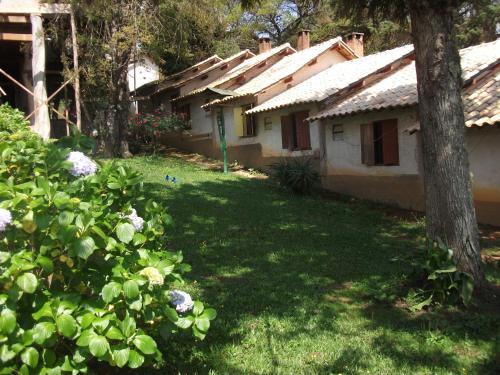 a yard of a house with trees and flowers at A Casinha Pequenina in Monte Verde