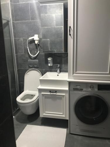 ein Badezimmer mit Toilette, Waschbecken und Waschmaschine in der Unterkunft Luxx Suite Nişantaşı in Istanbul