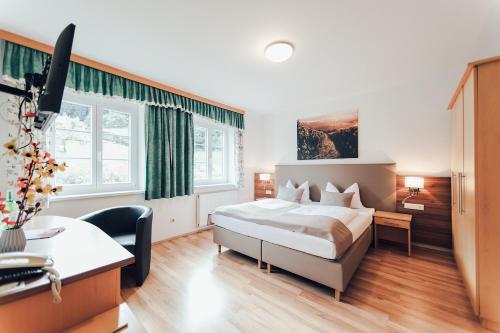 a hotel room with a bed and a desk at Gästehaus Kleindienst in Deutschlandsberg