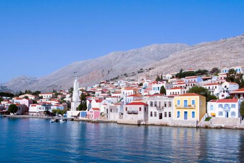 a group of houses on the shore of a body of water at Kleanthe in Halki