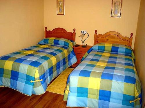 two beds sitting next to each other in a bedroom at La Loma in Boñar