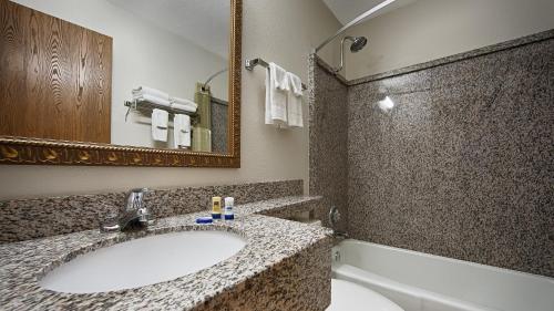W łazience znajduje się umywalka, toaleta i lustro. w obiekcie Best Western Mount Pleasant Inn w mieście Mount Pleasant