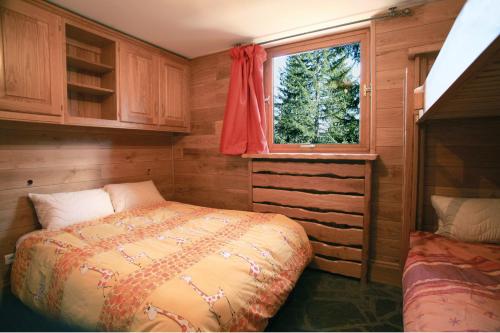 a small bedroom with a bed and a window at Chalet le trappeur à Courchevel 1850, Hammam in Courchevel