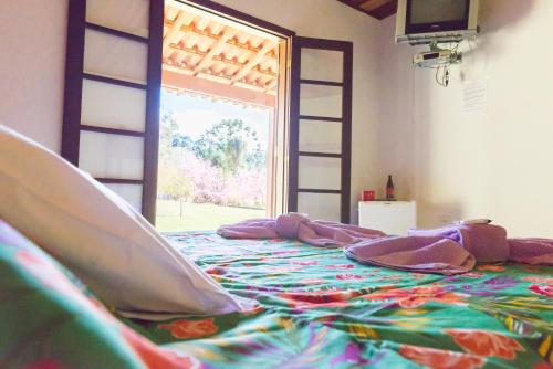 a bedroom with a large bed with a colorful blanket at Pousada das Flores in Gonçalves