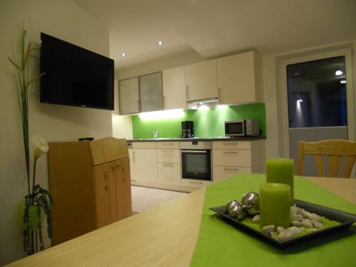 a kitchen with a table with a green wall at Haus Traninger in Flachau