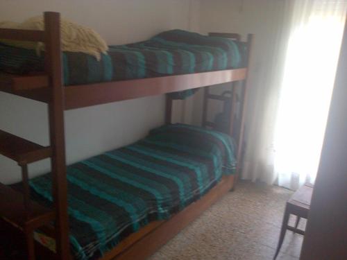 1 dormitorio con 2 literas con sábanas verdes en mar de ajo norte dto. 3 amb frente al mar P.B. en Mar de Ajó