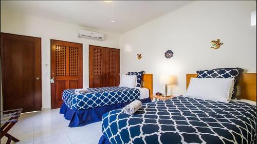 a bedroom with two beds with blue and white sheets at Playa Kaan Condominiums- Unit 22 in Playa del Carmen
