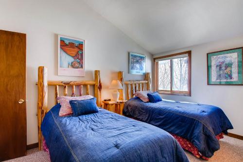 a bedroom with two beds and a window at The Plaza Condominiums by Crested Butte Mountain Resort in Mount Crested Butte