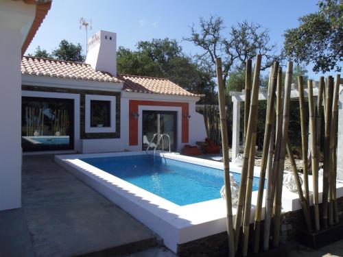 a swimming pool in front of a house at Monte dos Binos in Porto Covo