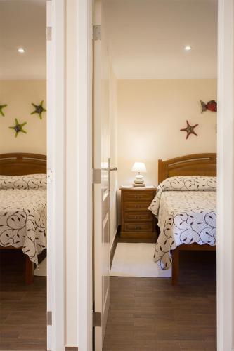 a bedroom with two beds and a table with a lamp at Casal Riquezo T2-1.o- Serra da Pescaria - Nazare in Nazaré