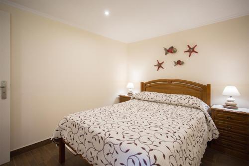1 dormitorio con 1 cama con estrellas en la pared en Casal Riquezo T2-1.o- Serra da Pescaria - Nazare, en Nazaré