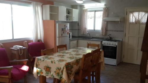 cocina con mesa y sillas y cocina con refrigerador en Pinamar pato duplex - Solo Familias en Pinamar