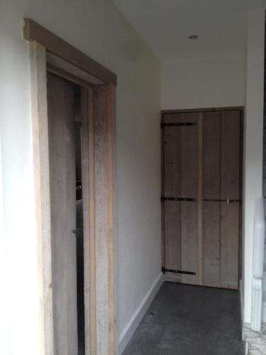 an empty room with wooden doors and a room with at Vakantiewoning Margaux -free parking - Sauna in Bruges
