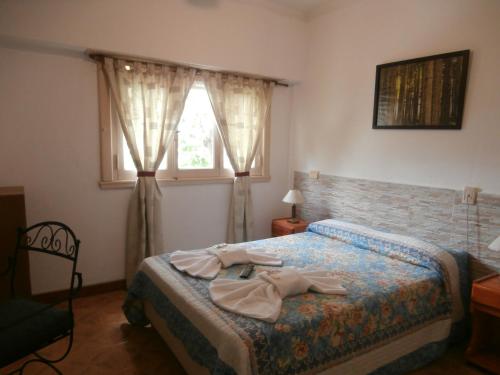 a bedroom with a bed with two towels on it at Hotel El Circulo in Mar del Plata