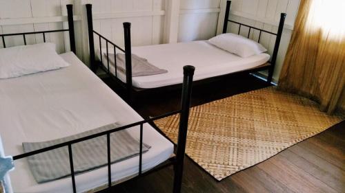 two bunk beds in a room with a wooden floor at Rareheart Guesthouse in Kuala Terengganu