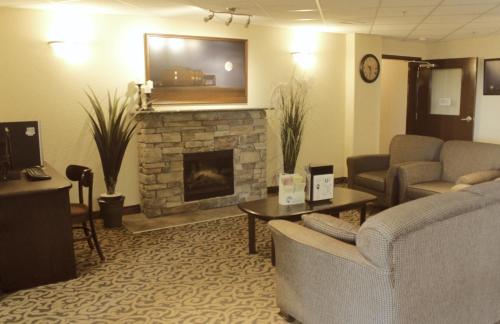 a living room with a couch and a fireplace at Prairie Moon Inn & Suites Unity in Unity