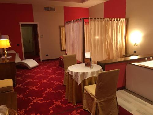 a room with a table and chairs in a hotel room at Hotel Don Carlo in Broni