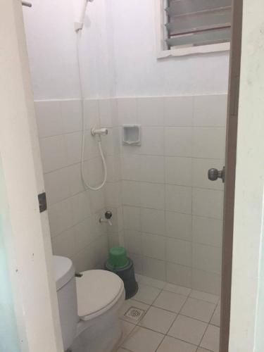 a small bathroom with a toilet and a shower at Cliff Side Beach Resort and Cottages in Lomangcapan