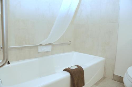 La salle de bains est pourvue d'une baignoire blanche et de toilettes. dans l'établissement Prairie Moon Inn & Suites Macklin, à Macklin