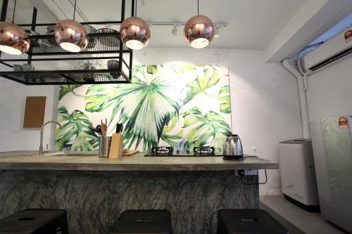 a kitchen with a counter with a mural of palm trees at Stay SongSong Beach Street in George Town
