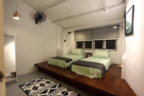 een slaapkamer met 2 bedden en een spiegel bij Stay SongSong Beach Street in George Town