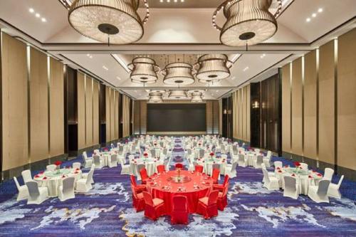 a large banquet hall with red tables and white chairs at Wanda Realm Resort Nanning in Nanning