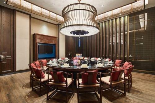 a dining room with a table and chairs and a chandelier at Wanda Realm Resort Nanning in Nanning