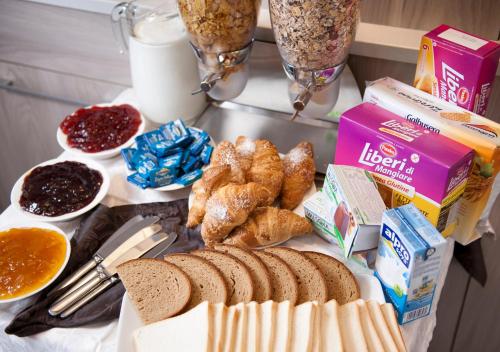 a table with bread and pastries and other breakfast foods at Hotel Gamma in Milan