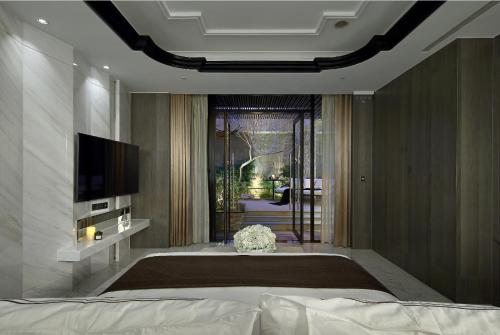 a bedroom with a large bed and a television at Ease Motel Taichung in Taichung