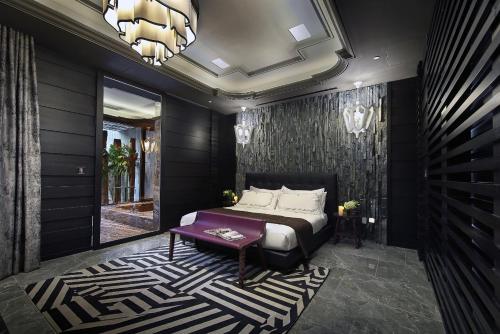 a bedroom with a bed and a table and a chandelier at Ease Motel Taichung in Taichung