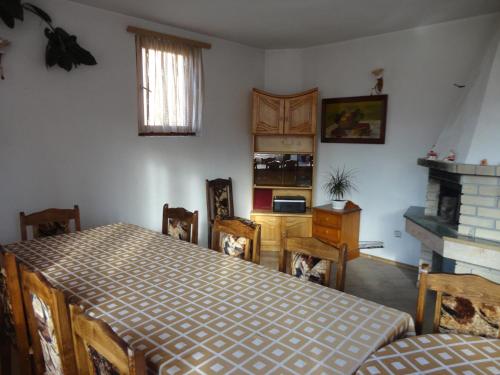 una sala da pranzo con tavolo, sedie e camino di Guest Rooms Grachenovi a Bansko