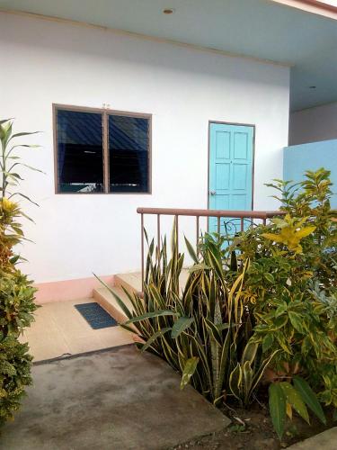 a house with a porch and a window and plants at Peace Pool Resort in Khun Han