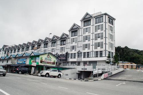 a large white building on the side of a street at Wan Alyasa Hotel in Cameron Highlands